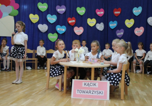 grupa dzieci siedzi przy stoliku
